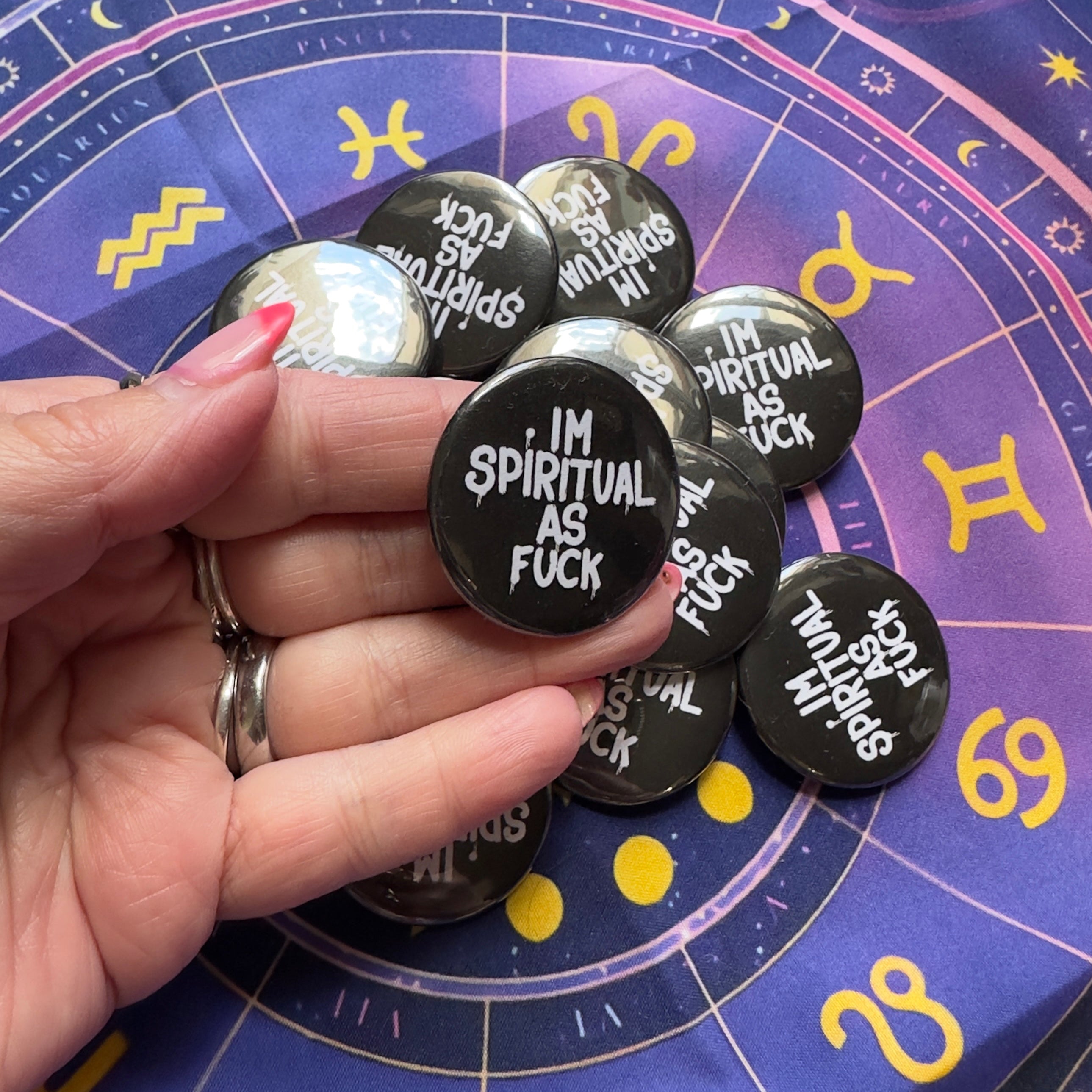 Hand holding buttons with text on an astrological chart background
